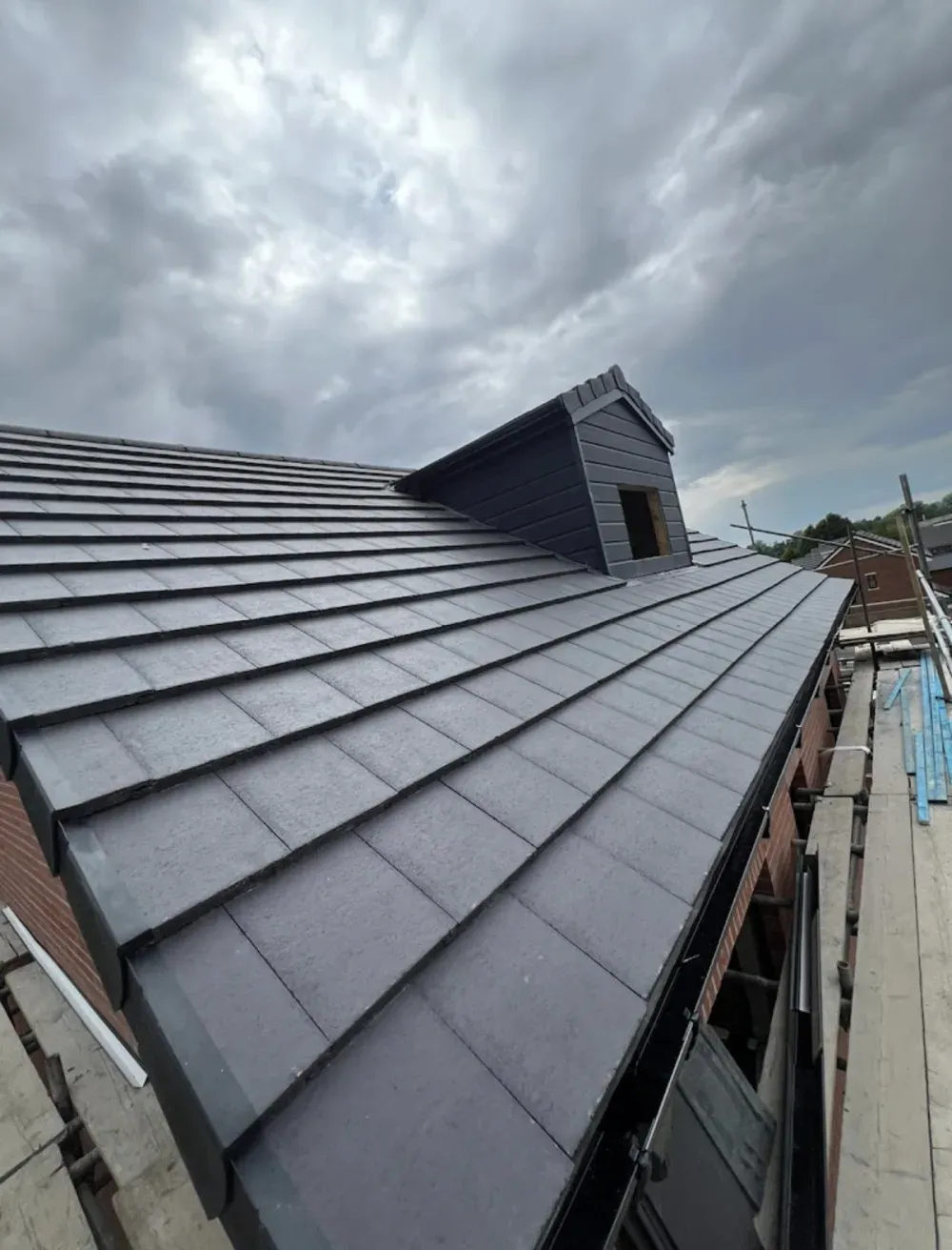 New roof finished in dark grey slate-effect tiles with a clad dormer